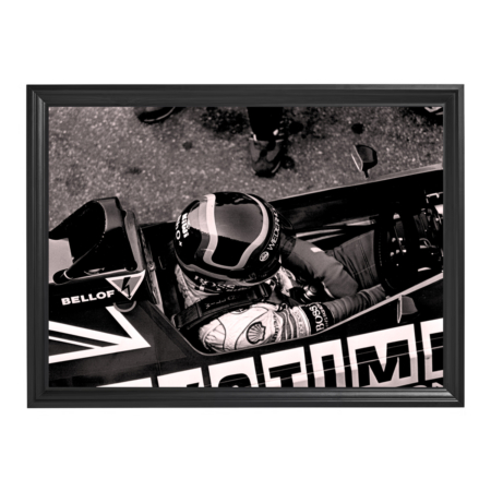 Framed black-and-white photo of Stefan Bellof seated in Formula race car cockpit.